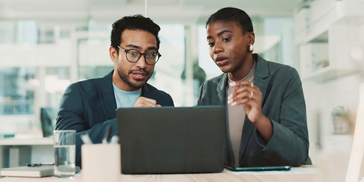 Business team reviewing data on laptop together
