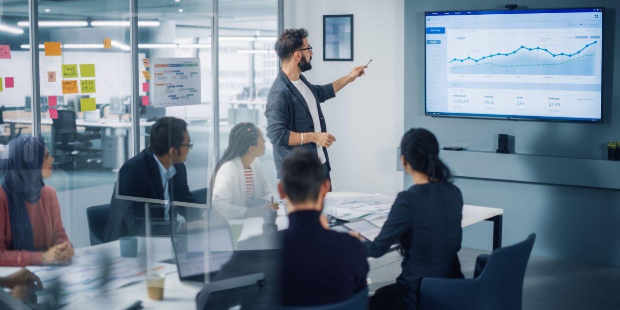 Discussing data on a large screen.