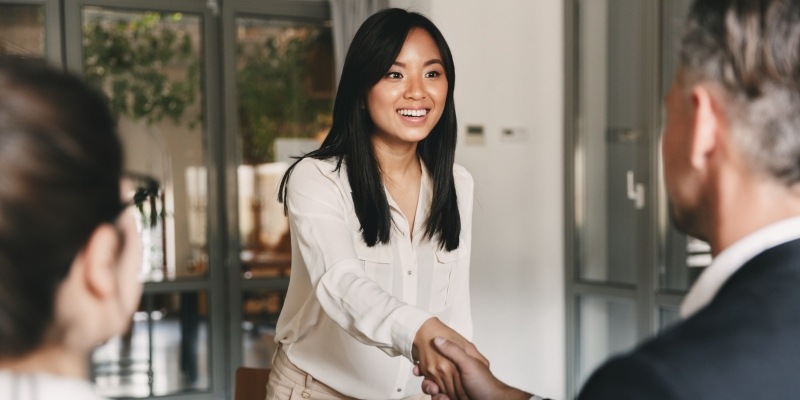 Smiling employee candidate shaking hands.