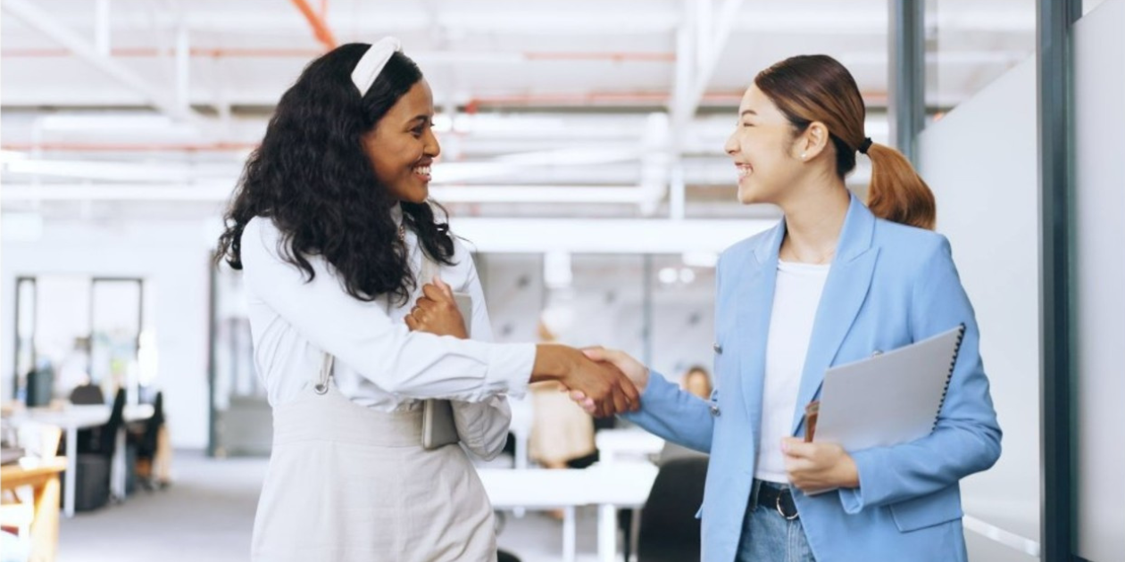 two female colleagues shaking hands