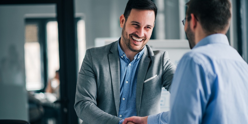 Smiling colleagues shaking hands.