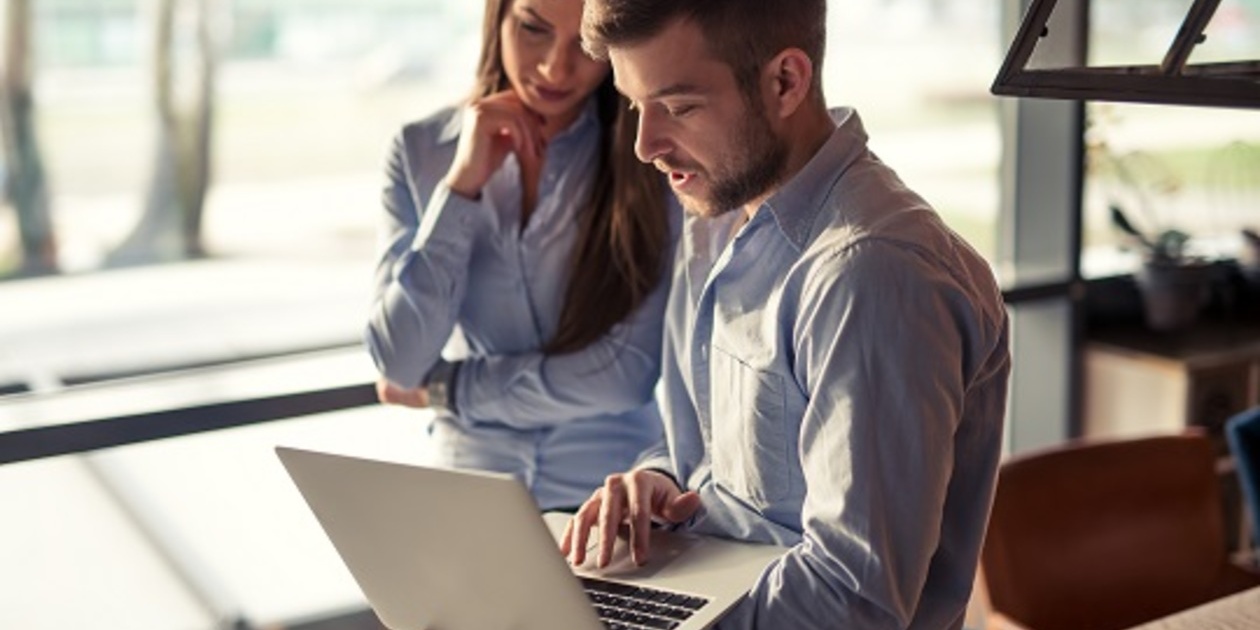 Two people disscussing information on a laptop