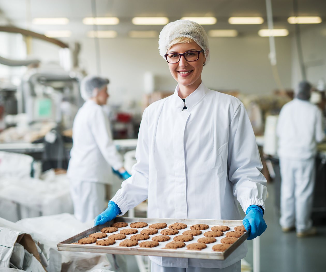This picture of a professional baker holding a pan of chocolate chip cookies is an example of a Remedi food and beverage client.